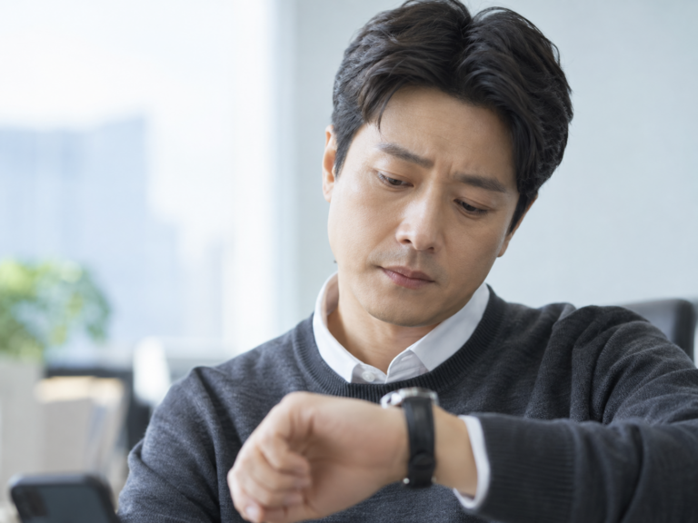 바쁜 일정으로 시계를 확인하는 40대 남성